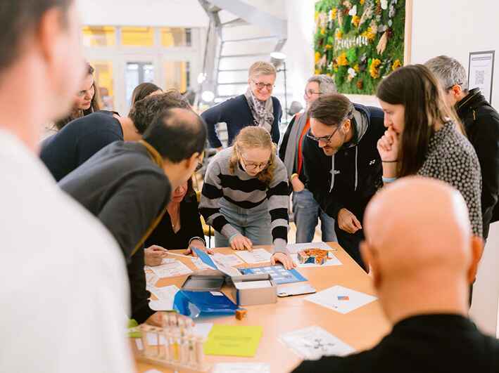 Des collaborateurs en entreprises sont à jouer autour d'une table à l escape game code climat lors de leur team building rse